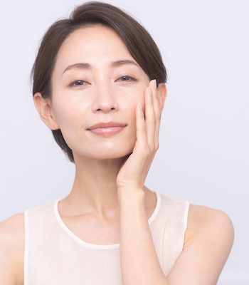 Skin care. Woman with beauty face touching healthy facial skin portrait. Asian woman.